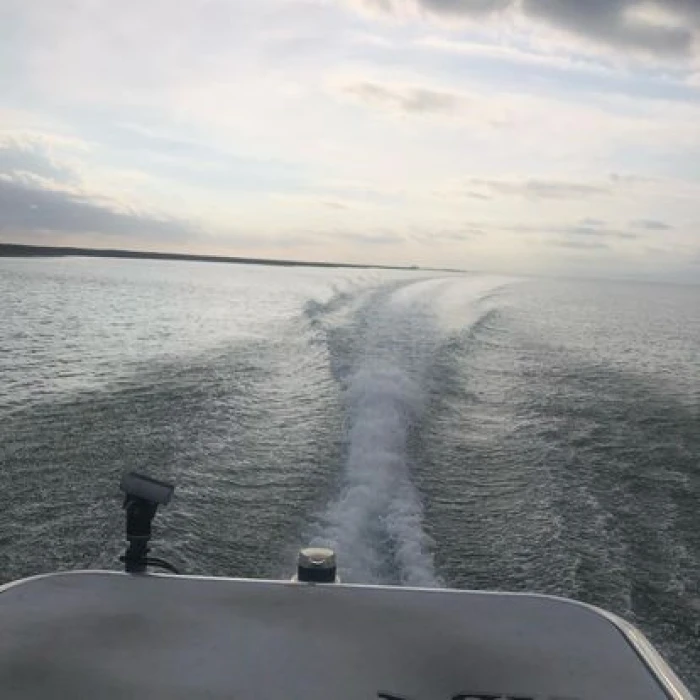 Boat wake trail on calm water.